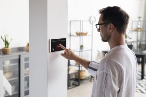 man using tablet in his smart home scaled